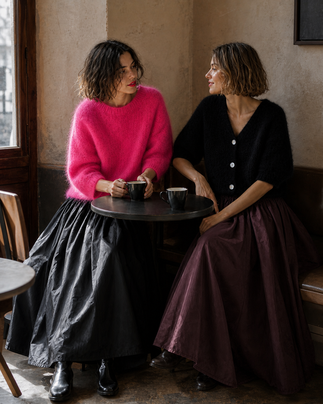 Zwei Freundinnen im Café in Pink, Schwarz und Bordeaux