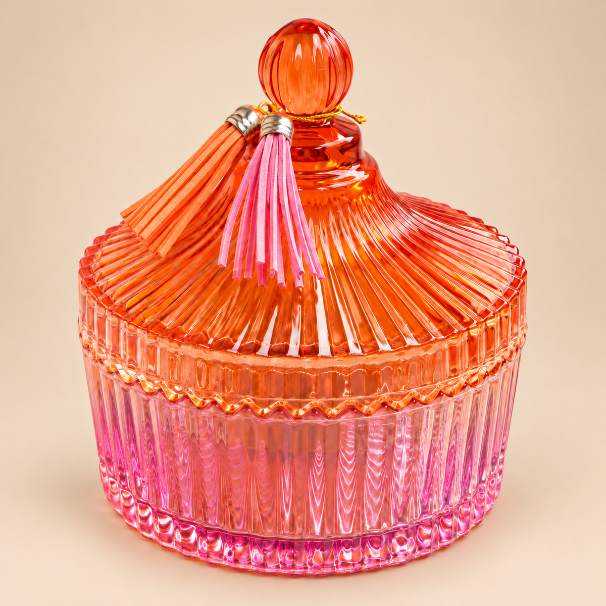 Gerippte Glasdose mit orangefarbenem Deckel, rosafarbenem Unterteil und Quasten