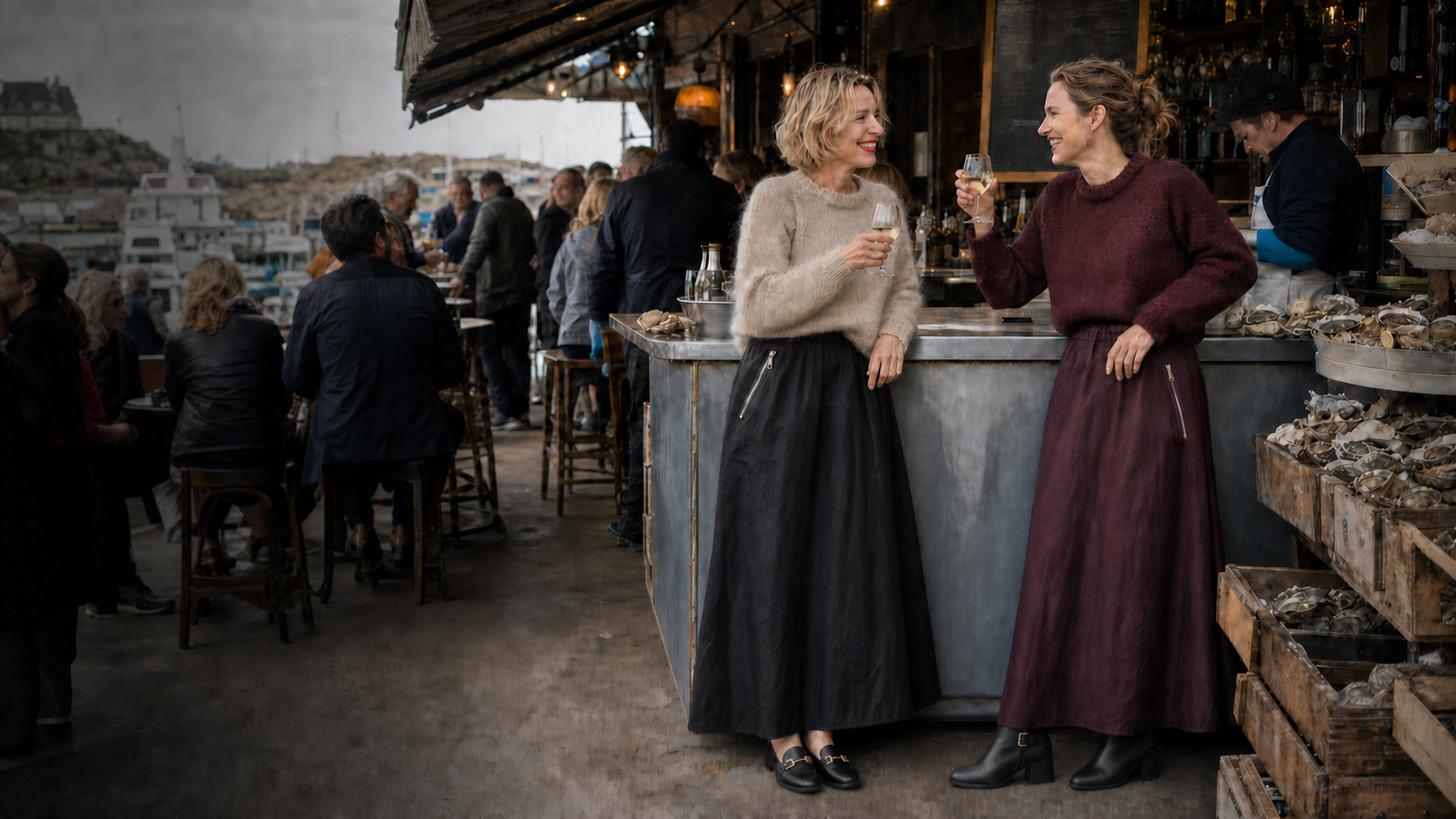 Zwei Freundinnen in Susanne-Bommer-Looks stoßen an einer lebendigen Austernbar an